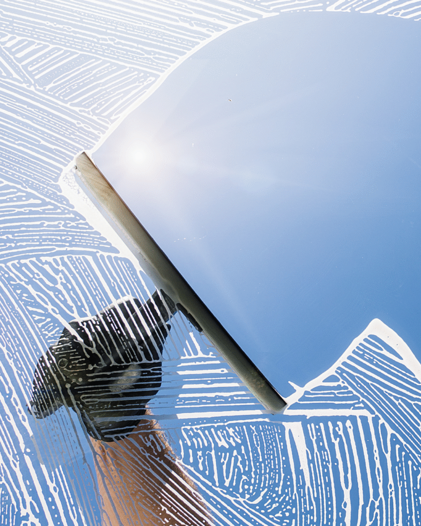 Interior window being cleaned with a squeegee, leaving a streak-free finish and clear view
